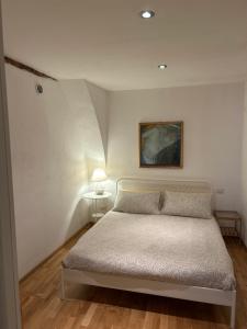 a bedroom with a bed and a painting on the wall at Ibiscus apartment in Cagliari