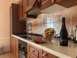 a kitchen with a bottle of wine and a bowl of fruit at Apartmani 'Bodulo' in Povljana