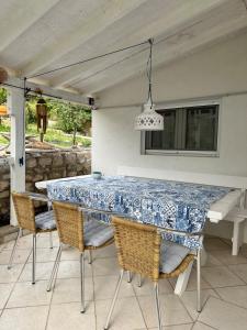a blue and white table and chairs on a patio at Little Beachouse Prvic Island in Prvić Šepurine