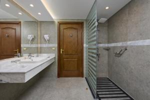 a bathroom with two sinks and a shower at Palm Royale Resort - Soma Bay in Hurghada