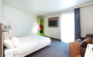 a bedroom with a white bed and a green cabinet at Campanile Clermont Ferrand Centre in Clermont-Ferrand +62 photos