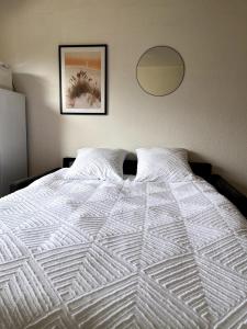 1 cama blanca en un dormitorio con una foto en la pared en Studio proche plage et centre-ville, en Sainte-Maxime 23 fotos más