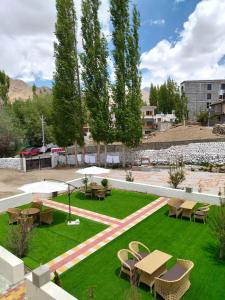 a park with picnic tables and chairs on grass at Two Flower Guest House in Leh +6 photos