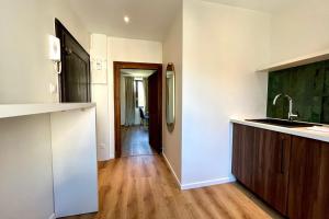 ナンシーにあるNancy Pépinière Appartement rénové et équipéのシンクと冷蔵庫付きのキッチン +2枚の写真