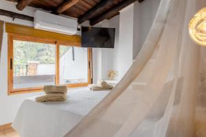 a bedroom with a bed with towels and a window at Alojamiento el Campanario in Cazorla