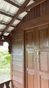 a wooden door of a house with a roof at Chinta Chinta Cottage Chalet Kayu in Arau