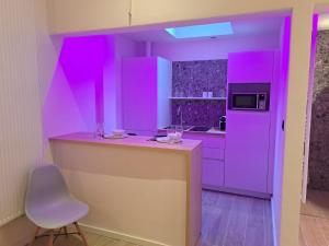 a purple kitchen with a counter and a chair at Boomgaard de Luxe in Antwerp