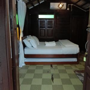 a small bedroom with a bed with white pillows at Chinta Chinta Cottage Chalet Kayu in Arau