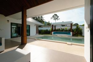 an empty house with a swimming pool in front of a house at Samui Paradise Poolside Villa in Nathon Bay
