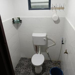 a small bathroom with a toilet and a window at Chinta Chinta Cottage Chalet Kayu in Arau