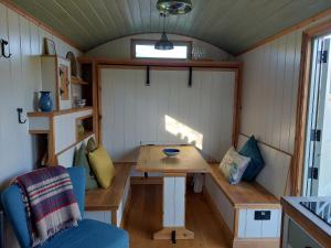 a tiny house with a table and a bench at Steam and Stars Luxury Glamping in Williton