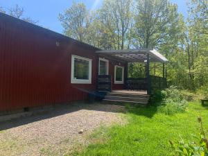 DrottningskärAspö Estates的红色的房子,设有门廊和甲板