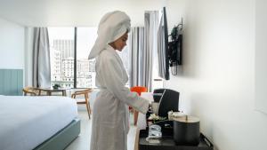 a woman standing in a hotel room with a bed at Dayton Vitality Hotel - Downtown in Dayton +52 photos