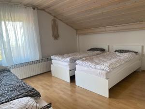two beds in a room with wooden ceilings at Green Hill in Jesenice na Dolenjskem