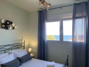 une chambre avec un lit et une fenêtre avec l'océan dans l'établissement Lilikas Sea Front Apartments 4, à Lilikás
