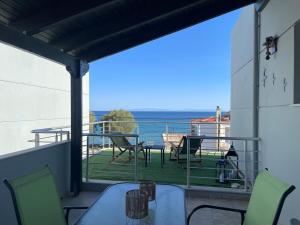 un balcon avec une table et des chaises et une vue sur l'océan dans l'établissement Lilikas Sea Front Apartments 4, à Lilikás