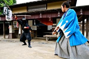 two people dressed in traditional kimonos standing in front of a building at Homm Stay Nagi Arashiyama Kyoto By Banyan Group in Kyoto