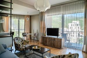 Una sala de estar con un sofá y un televisor. en The Royal Summer & Spa, en Bečići