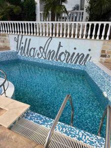 a swimming pool with a sign on the side of a building at Villa Antorini in Sveti Vlas