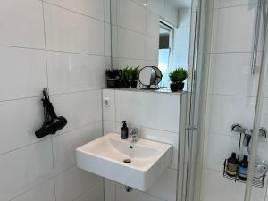 ルートヴィヒスブルクにあるbella casa - Family&Business, 100m zum Konzerteingang Schloß, Parkplatz, SmartTV, Netflix, Waschmaschine, 24h Checkin, 30qm, AP1の洗面台とシャワー付きの白いバスルーム +31枚の写真