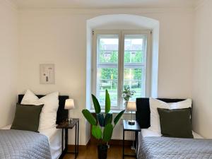 ルートヴィヒスブルクにあるbella casa - Family&Business, 100m zum Konzerteingang Schloß, Parkplatz, SmartTV, Netflix, Waschmaschine, 24h Checkin, 30qm, AP1のベッド2台と窓のある寝室