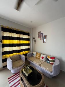 a living room with two couches and a table at Premium 1BHK Homestay in Jorhat in Jorhāt