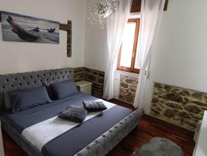a bedroom with a bed with blue sheets and a window at La Cascina del Borgo in Riccò del Golfo di Spezia