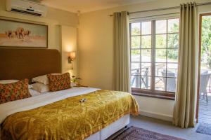 a bedroom with a bed and a large window at 5 Seasons Guest House in Stellenbosch +138 photos