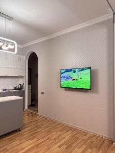 a living room with a flat screen tv on a wall at Private Comfortable Modern Flat in Xirdalan