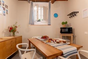 une salle à manger avec une table et des chaises en bois dans l'établissement Loft il Chiostro della Cattedrale, à Lucques