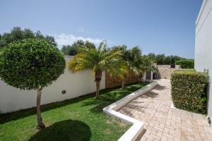 une cour avec des palmiers à côté d'un bâtiment dans l'établissement Roupes Villa II, Family villa, Fantastic views, Private pool, à Roúpai