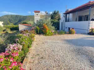 un vialetto con fiori di fronte a una casa di Lake Side Serenity a Ksamil