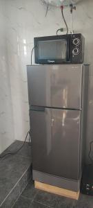 a microwave sitting on top of a refrigerator at Résidence Yemissi in Cotonou +21 photos