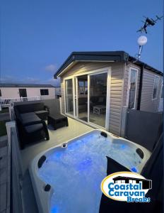 a hot tub on the deck of a house at Fantasy Island - Eastgate F5- The Ardennes with Hot Tub - Coastal Caravan Breaks in Ingoldmells