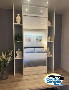 a bedroom with a bookcase with a bed in it at Fantasy Island - Eastgate F5- The Ardennes with Hot Tub - Coastal Caravan Breaks in Ingoldmells