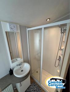a bathroom with a shower and a sink at Fantasy Island - Eastgate F5- The Ardennes with Hot Tub - Coastal Caravan Breaks in Ingoldmells