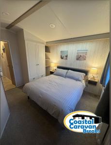 a bedroom with a large bed and two lamps at Fantasy Island - Eastgate F5- The Ardennes with Hot Tub - Coastal Caravan Breaks in Ingoldmells