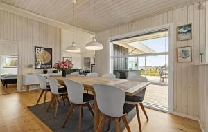 a dining room with a wooden table and chairs at Holiday Home Stenh in Rønde