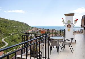 een balkon met een tafel en stoelen en de oceaan bij Panoramic Sea-View I 2-Bedroom Flat with Terrace by Flat Manаger in Balchik