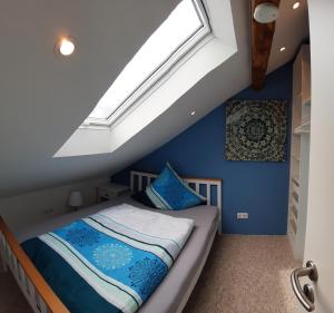 a attic bedroom with a bed with a skylight at ApartmentHotel Vollumen in Redwitz an der Rodach