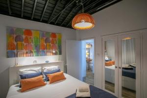 una camera da letto con un letto con cuscini arancioni e un dipinto di GuestReady - OceanFront Lookout House a Ponta Delgada