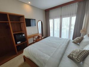 a bedroom with a large bed and a television at Villa Lovecho in Canggu