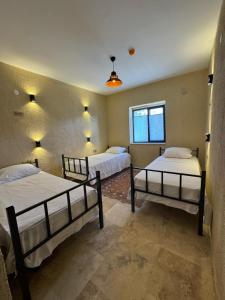 a bedroom with two beds and a window at Wanderlust Inn Cappadocia in Uçhisar