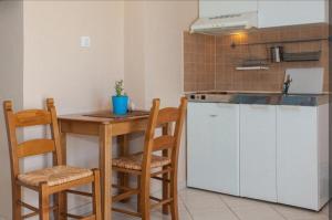 a kitchen with a counter and a table and chairs at Elena studio 2 in Vouvás