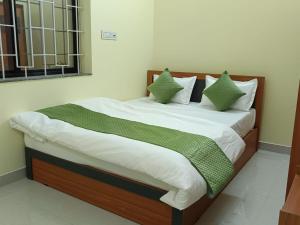 a bed with green and white sheets and pillows at Hotel Silver Park and Restaurant in Bilāspur