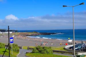 eine Gruppe von Menschen an einem Strand in der Nähe des Ozeans in der Unterkunft Ninho do Cedro - Azorean tranquility in Livramento