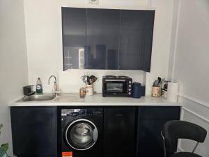 a kitchen with a washing machine and a microwave at Newly Built Studio Apartment in Weston