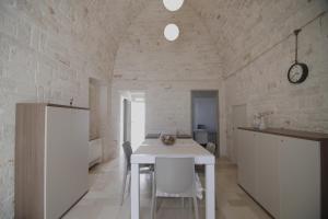 a kitchen and dining room with a white table and chairs at Dimore Vino&Amore in Alberobello