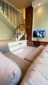 a living room with a couch and a tv at 2 Bedroom Villa In Sanur Harbour in Sanur
