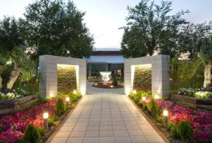 a walkway in a garden with flowers and lights at Complejo La Cigüeña in Arganda del Rey